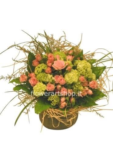 Cestino di vimini o ceramica, rose e verde pregiato.